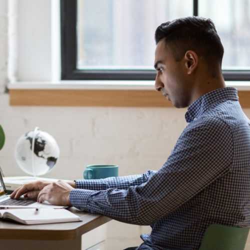 man-sitting-on-green-chair-while-using-laptop-374831cropped